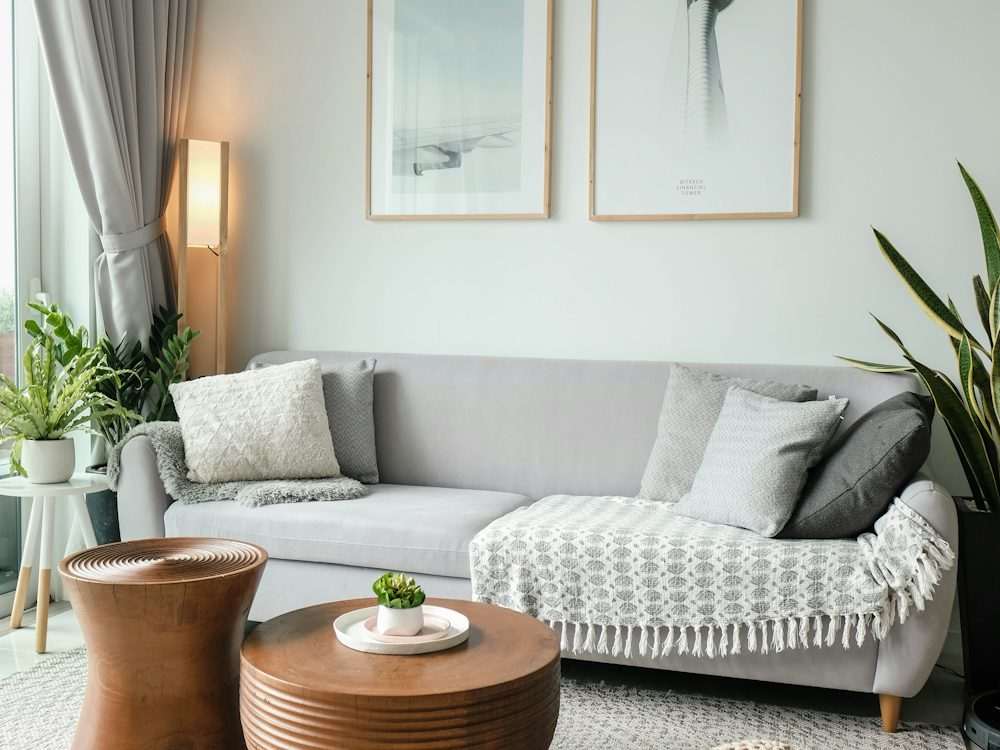 A living room with a grey sofa and side table